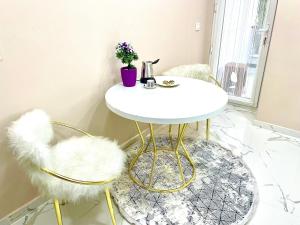 una mesa blanca y 2 sillas en una habitación en MONEZZA APART, en Avcılar