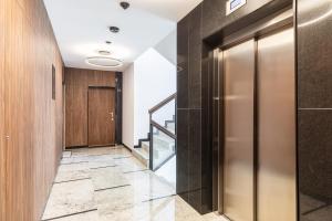 a hallway with a elevator and a staircase at SuperApart St. Augusta 71 in Warsaw