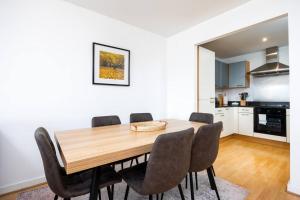 uma sala de jantar com uma mesa de madeira e cadeiras em Lovely 2 BR apartment with balcony em Dublin