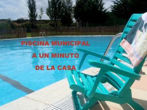 una silla azul sentada junto a una piscina en Entreacebedas rural&vacaciones, alojamientos con jardín a una hora de Madrid GASTRONOMÍA Y AHORRO, en Segovia