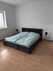 a bed sitting in a room with a bed frame at Apartament Dąbrówno in Dąbrówno