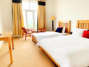 a hotel room with two beds and a desk at Hispar Hotel Skardu in Skardu