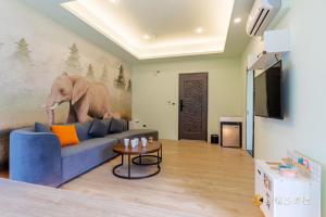 宜蘭市的住宿－武暖Zoo親子民宿（新館），客厅配有蓝色的沙发和一幅大象画