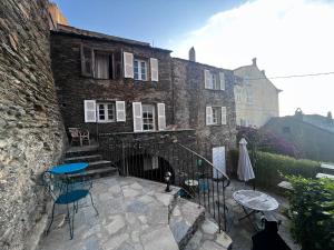 a patio with chairs and tables and a building at Torra di Ciocce in Pino