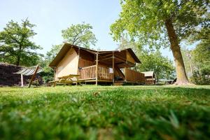 RenswoudeGlamping Renswoude的一座带门廊和树的房子
