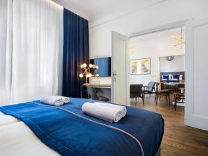 a bedroom with a blue bed with two towels on it at Tyzenhauz Grand Apartaments in Kraków