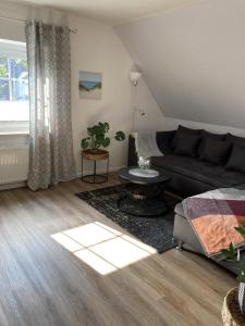 ein Wohnzimmer mit einem Sofa und einem Tisch in der Unterkunft NEU Ferienwohnung Hofmann in Husum