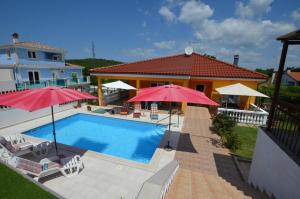 a house with a swimming pool with two umbrellas at Mari House in Kanfanar