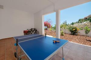 una mesa de ping pong azul en el medio de una habitación en Villa la Colina with heated pool and jacuzzi, en Salobreña