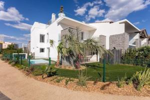 a white house with a fence in front of it at VILLA D'EXCEPTION - MARINA PISCINE ROOFTOP 10 PERSONNES - 4 Etoiles in Cap d'Agde