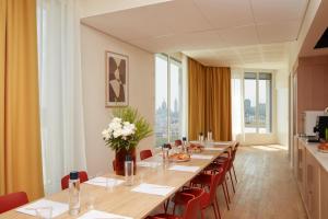 パリにあるOKKO Hotels Paris Rosa Parksの長いダイニングルーム(長いテーブルと椅子付)