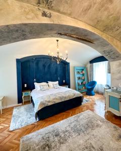 a bedroom with a large bed with a blue headboard at MAGISTER seven in Sibiu