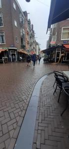una calle adoquinada con gente caminando por la calle en Room Charlotte, not hotel, no parties, no kitchen en Ámsterdam