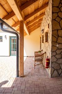 a patio with a stone wall and a wooden ceiling at U Katalpy in Sedlec