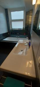 lavabo blanco en un baño con ventana en Room Charlotte, not hotel, no parties, no kitchen en Ámsterdam