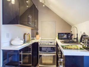 a kitchen with stainless steel appliances and black cabinets at The Studio in Dinmore