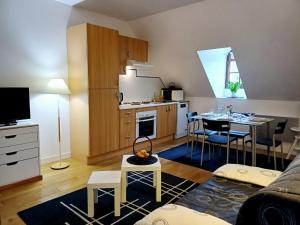 een woonkamer met een keuken en een tafel met stoelen bij Le Jardin des Lys in La Roche-Posay