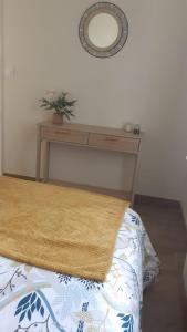- une chambre avec un lit, une table et un miroir dans l'établissement Petite maison ensoleillée à 10 minutes du port de Vannes, à Vannes