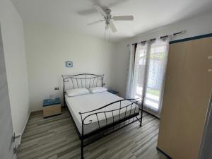 a bedroom with a bed and a ceiling fan at VILLA SALICE 9.2 in Isola Albarella +11 photos