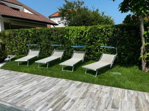 a group of benches sitting in the grass at VILLA SALICE 9.2 in Isola Albarella