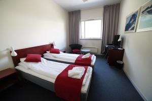 um quarto de hotel com duas camas com almofadas vermelhas em Sitla Hotel & Appartments em Øvre Årdal