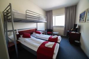 Sitla Hotel & Appartments في Øvre Årdal: غرفة في الفندق مع سريرين بطابقين ومكتب