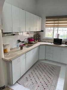 a kitchen with white cabinets and a rug on the floor at Traditional Palestinian Home in Beit Sahour