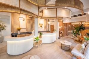 a lobby of a hotel with a reception counter and tables at Hotel Wizpark Ratchada in Bangkok