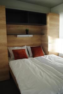 un grande letto bianco con due cuscini rossi sopra di Mobile House Pirovac Kamp Kerido a Pirovac (Slosella)
