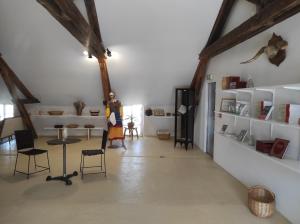 ein Zimmer mit weißen Regalen und einer Frau in einem Zimmer in der Unterkunft Le Moulin Neuf in Brienon-sur-Armançon
