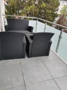 two wicker chairs and a table on a balcony at Ferienwohnungen Alpenliebe & Auszeit in Sonthofen