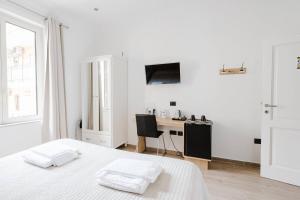 a white bedroom with a bed and a desk at B&B Giacomino in Sorrento