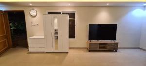 a living room with a flat screen tv and a clock at إستراحة الدنيس الونيس in Riyadh