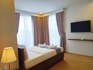 um quarto de hotel com uma cama e uma televisão de ecrã plano em INNCITY HOTEL em Calbayog