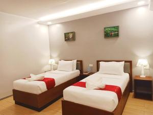 2 camas en una habitación de hotel con 2 lámparas en INNCITY HOTEL, en Calbayog