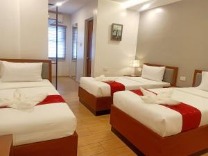 pokój hotelowy z 2 łóżkami z czerwoną i białą pościelą w obiekcie INNCITY HOTEL w Calbayog