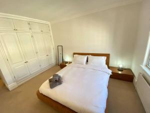 1 dormitorio con 1 cama blanca grande y 2 mesas en Wonderful Baker Street Flat!, en Londres
