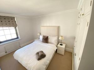 Un dormitorio blanco con una cama con un elefante. en Wonderful Baker Street Flat!, en Londres