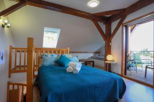 a bedroom with a blue bed with towels on it at L'Écrin Vue Lac 3 étoiles - Parking gratuit, Calme & confort in Sévrier