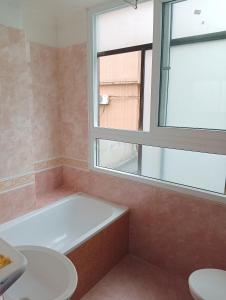 a bathroom with a bath tub and a window at Sunny B Hotel in Hue