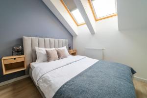 a bedroom with a large bed in a attic at Lake Rental Spacerowa in Mikołajki