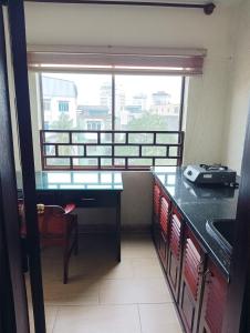 a kitchen with a table and a large window at Sunny B Hotel in Hue
