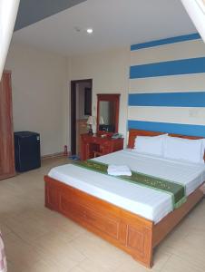 een slaapkamer met een groot bed in een kamer bij Sunny B Hotel in Hue