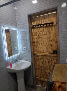 a bathroom with a sink and a wooden door at Our Village in Ashtarak
