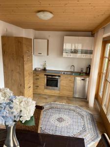 una cocina con un jarrón de flores sobre una mesa en Nabo Ferienwohnung Lechbruck, en Lechbruck