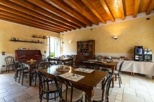 un ristorante con tavoli e sedie in una stanza di Agriturismo Corte Salandini a Ponti Sul Mincio