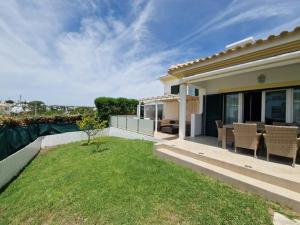 a house with a patio with a table and chairs at Villa Harvey in Albufeira