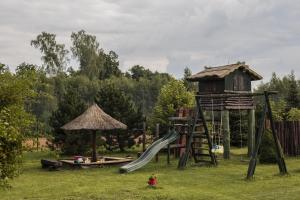 un parque infantil con tobogán y una casa en el árbol en AZURIA agroturystyka en Pisz