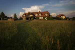 duży dom na polu wysokiej trawy w obiekcie AZURIA agroturystyka w Piszu
