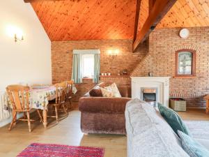 a living room with a couch and a table at Elm Tree Cottage in Melton Mowbray
